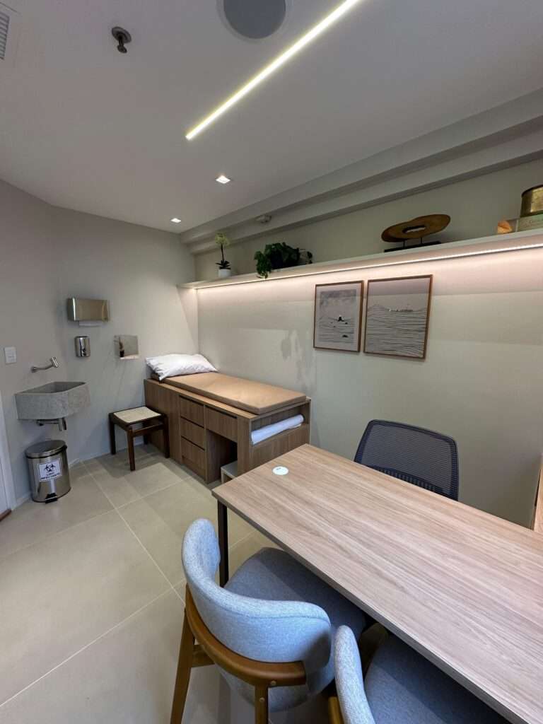 Consultório com mesa de atendimento e vista para a Vila Olímpia