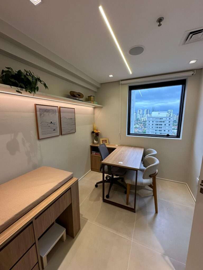 Consultório com maca de exame e vista para a cidade