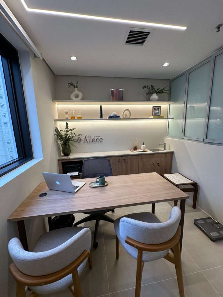 Consultório com mesa de atendimento e poltronas para o paciente